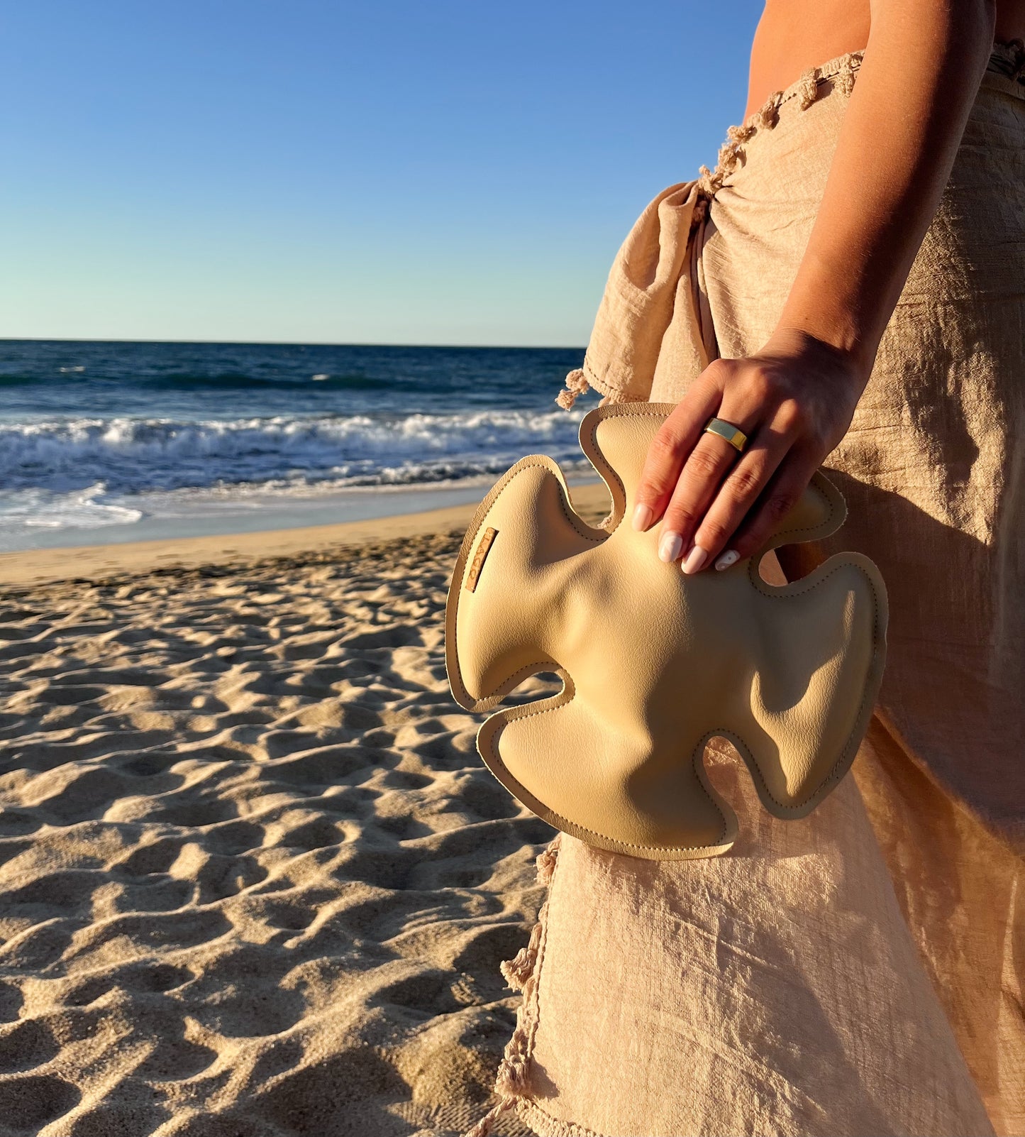 LAGO Stemmed Glass Stabilizer being held in beach setting.